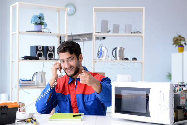 Young repairman fixing and repairing microwave oven Stock photo © Elnur