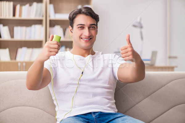 Man listening music sitting in couch Stock photo © Elnur