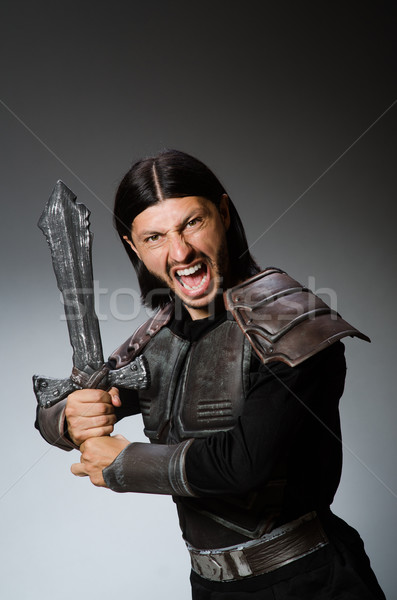 Angry knight with sword against dark background Stock photo © Elnur
