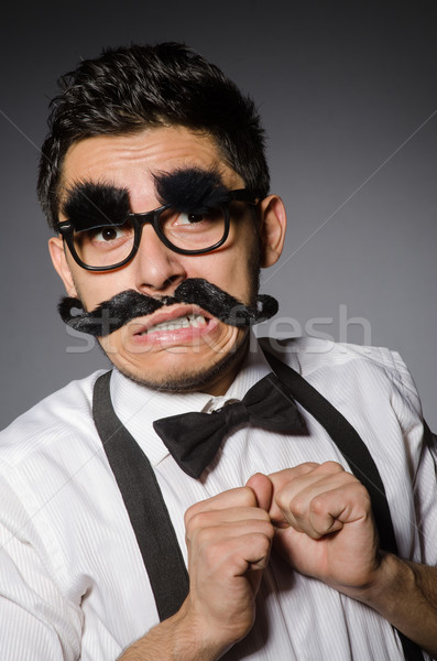 Jeune homme faux moustache isolé gris modèle Photo stock © Elnur