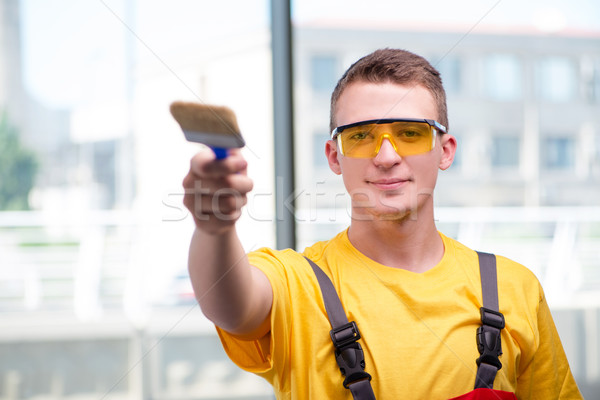 Stock photo: Young construction worker in yellow coveralls