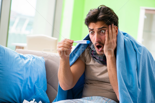 Sick young man suffering from flu at home Stock photo © Elnur