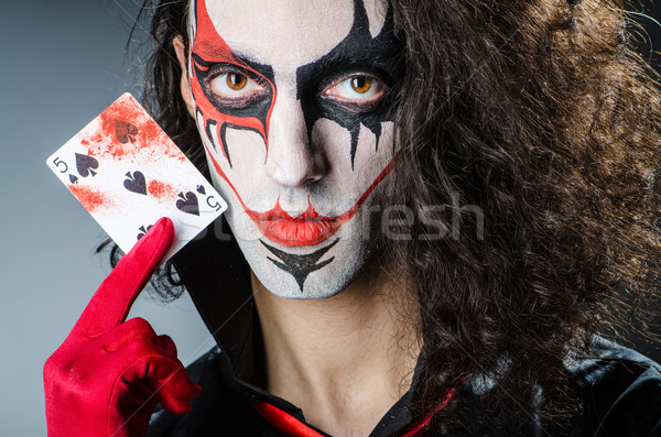 Evil clown with cards in dark room Stock photo © Elnur