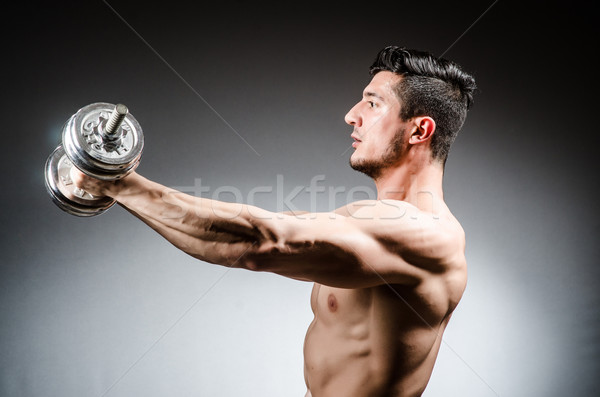 Stock photo: Muscular ripped bodybuilder with dumbbells