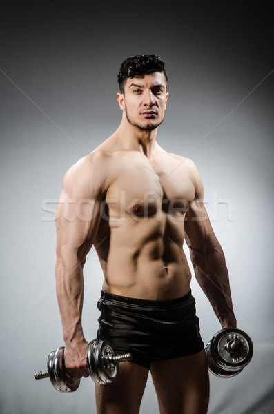 Stock photo: Muscular ripped bodybuilder with dumbbells