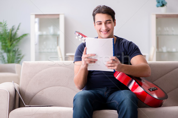 Young man practicing playing guitar at home Stock photo © Elnur