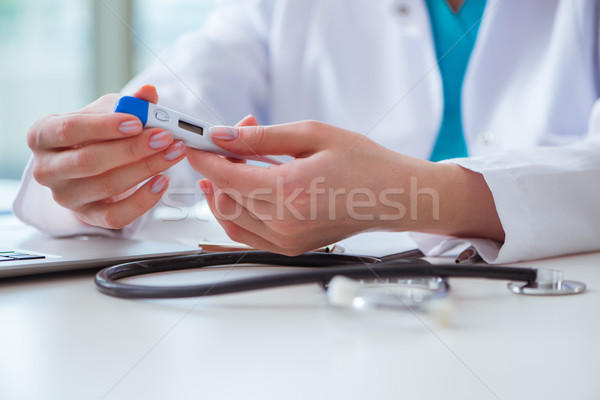 Doctor hand holding temperature thermometer Stock photo © Elnur