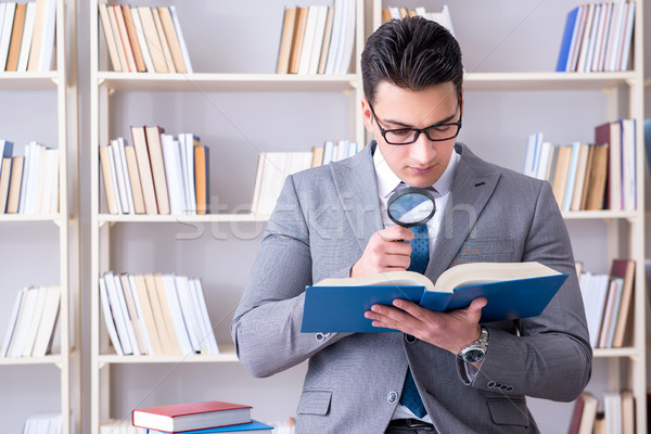 Business law student with magnifying glass reading a book Stock photo © Elnur