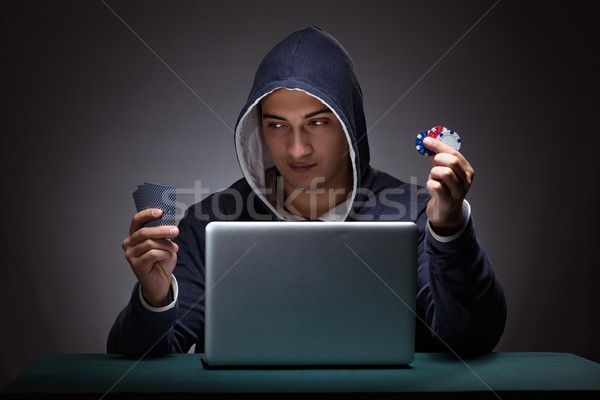 Young man wearing a hoodie sitting in front of a laptop computer Stock photo © Elnur