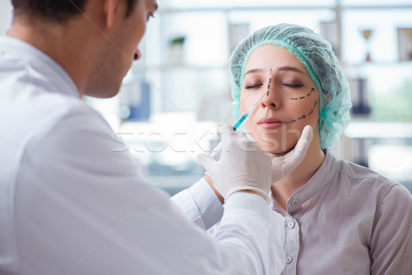 Stock photo: Plastic surgeon preparing for operation on woman face
