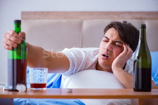 Man alcoholic drinking in bed going through break up depression Stock photo © Elnur