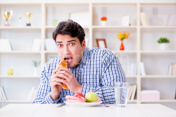 Man having dilemma between healthy food and bread in dieting con Stock photo © Elnur