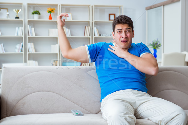 Man sweating excessively smelling bad at home Stock photo © Elnur