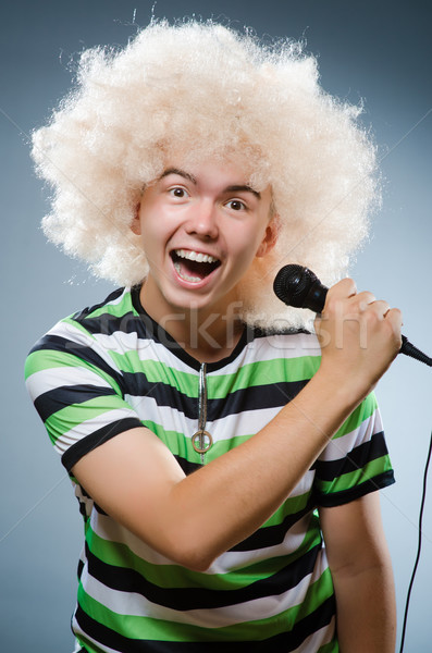 Man in afrowig singing with mic Stock photo © Elnur