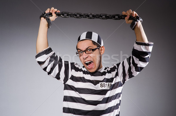 Young prisoner in chains against gray Stock photo © Elnur