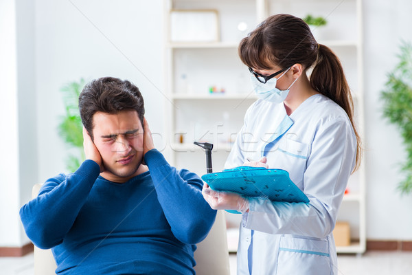 Stock photo: The doctor checking patients ear during medical examination