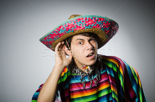 Stock photo: Man in vivid mexican poncho against gray