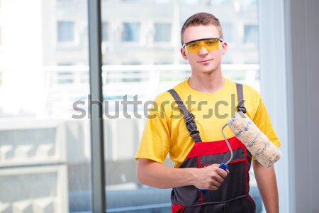 Young construction worker in yellow coveralls Stock photo © Elnur
