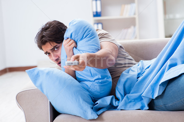 Man watching tv from bed holding remote control unit Stock photo © Elnur