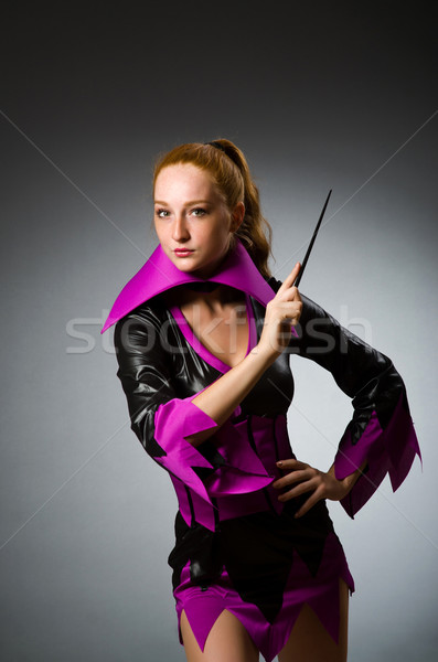 Female magician doing tricks on grey background Stock photo © Elnur