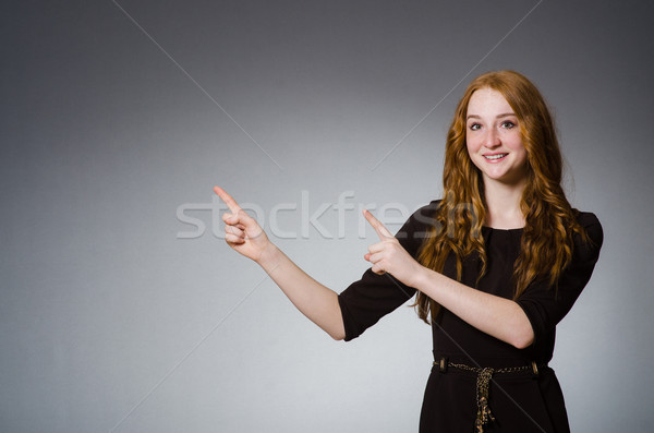 Stock photo: Pretty red hair girl in brown dress against gray