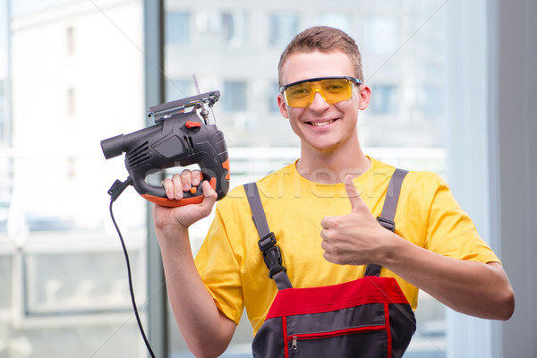 Young construction worker in yellow coveralls Stock photo © Elnur