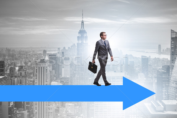 Businessman walking on arrow in business concept Stock photo © Elnur