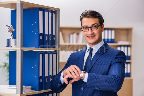 Young man standing next to the shelf with folders Stock photo © Elnur