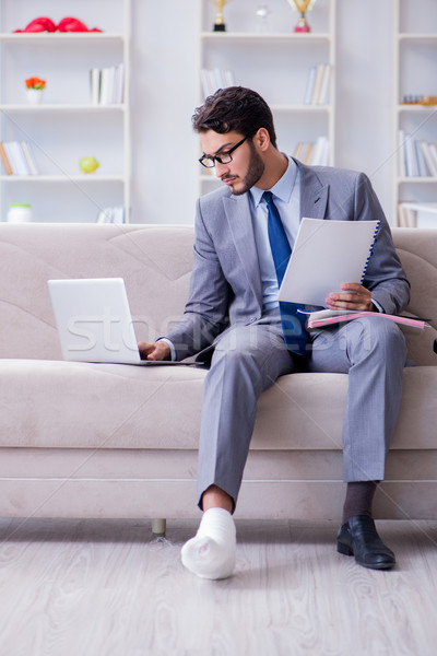 Businessman with crutches and broken leg at home working Stock photo © Elnur