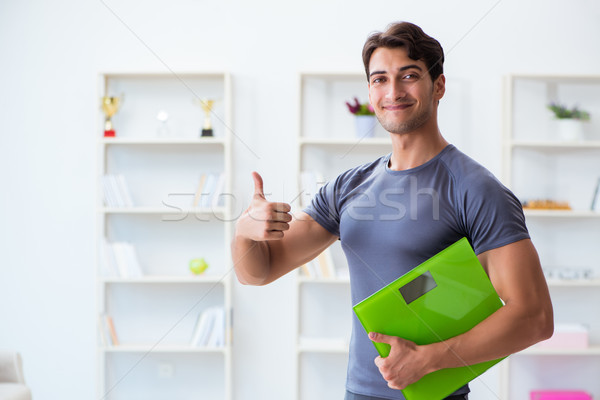 Man with scales in sports and health concept Stock photo © Elnur