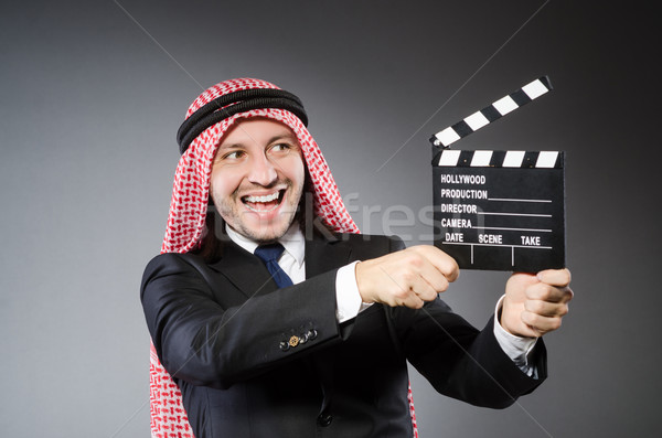 Arab man with movie clapper against grey background Stock photo © Elnur