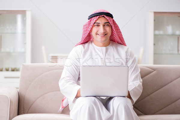 Fiatal arab üzletember dolgozik laptop kanapé Stock fotó © Elnur