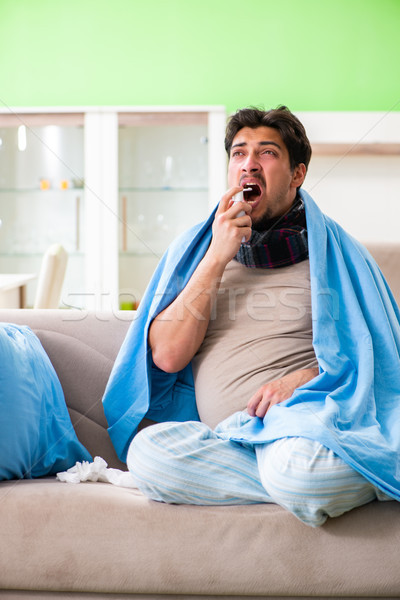 Sick young man suffering from flu at home Stock photo © Elnur