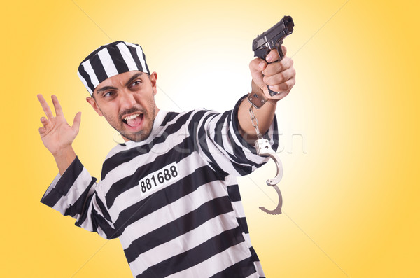 Stock photo: Prisoner with gun isolated on white