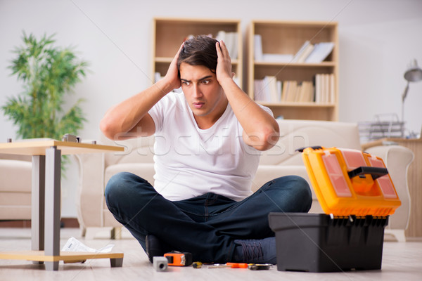 Stock photo: The man assembling shelf at home