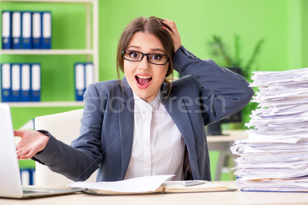 Young female employee very busy with ongoing paperwork Stock photo © Elnur