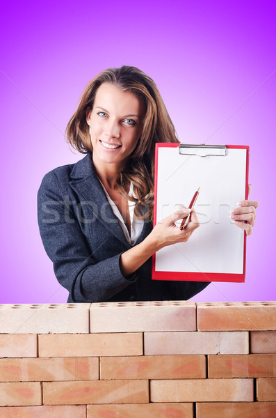 Stock photo: Woman builder and brick wall