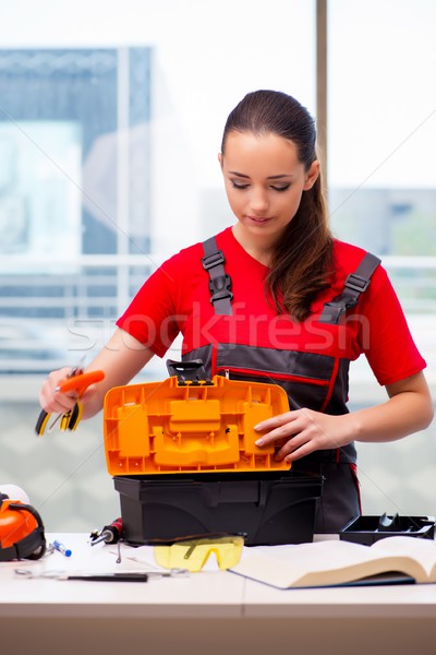 Young woman in coveralls doing repairs Stock photo © Elnur