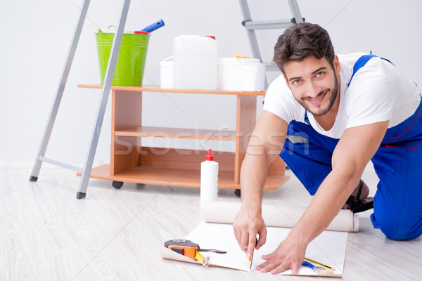Repairman doing renovation repair in the house with paper wallpa Stock photo © Elnur