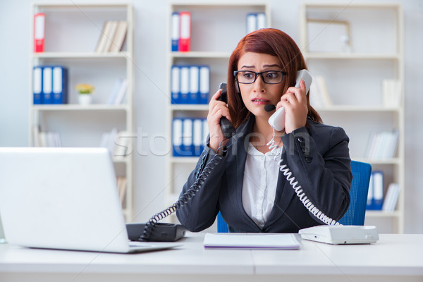 Stock photo: Frustrated call center assistant responding to calls