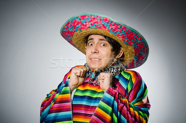 Stock photo: Man in vivid mexican poncho against gray