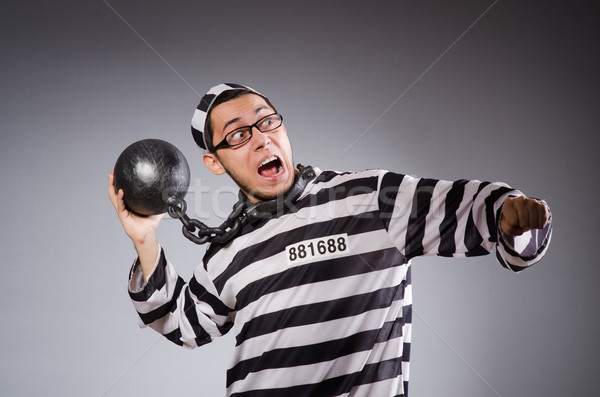 Stock photo: Young prisoner in chains against gray