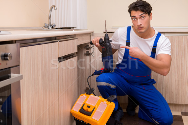 Young repairman working at the kitchen Stock photo © Elnur