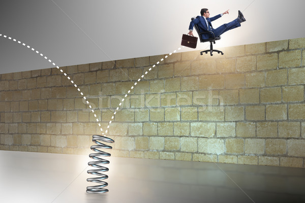 Businessman jumping from spring in business concept Stock photo © Elnur