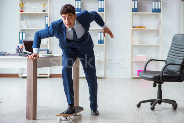 Young businessman with skate in office in sports concept Stock photo © Elnur