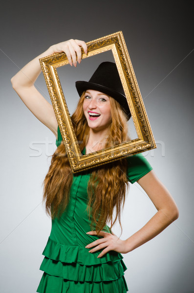 Woman wearing green dress holding picture frame Stock photo © Elnur