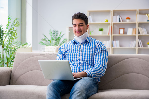 Man freelancer in a cervical collar neck brace working from home Stock photo © Elnur