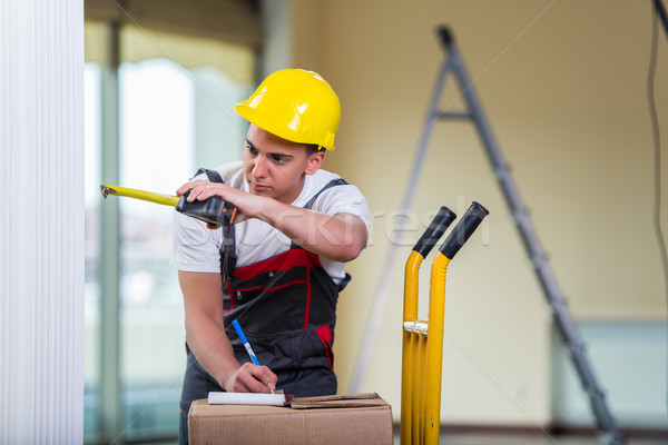Delivery man taking dimensions with tape measure Stock photo © Elnur