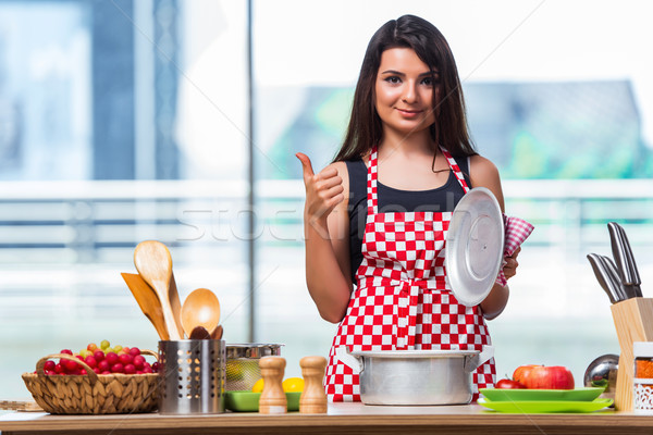 The female cook preparing soup in brightly lit kitchen Stock photo © Elnur
