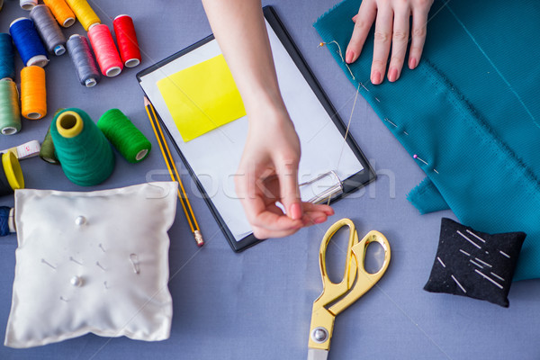 Stock photo: Woman tailor working on a clothing sewing stitching measuring fa